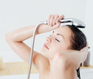 シャワーで髪を洗う女性
